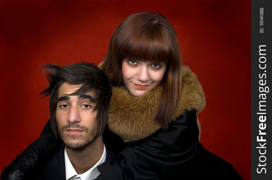 Portrait of young man and young women on red background
