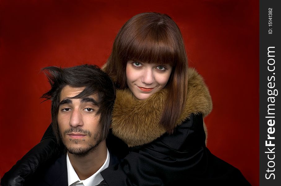 Portrait of young man and young women on red