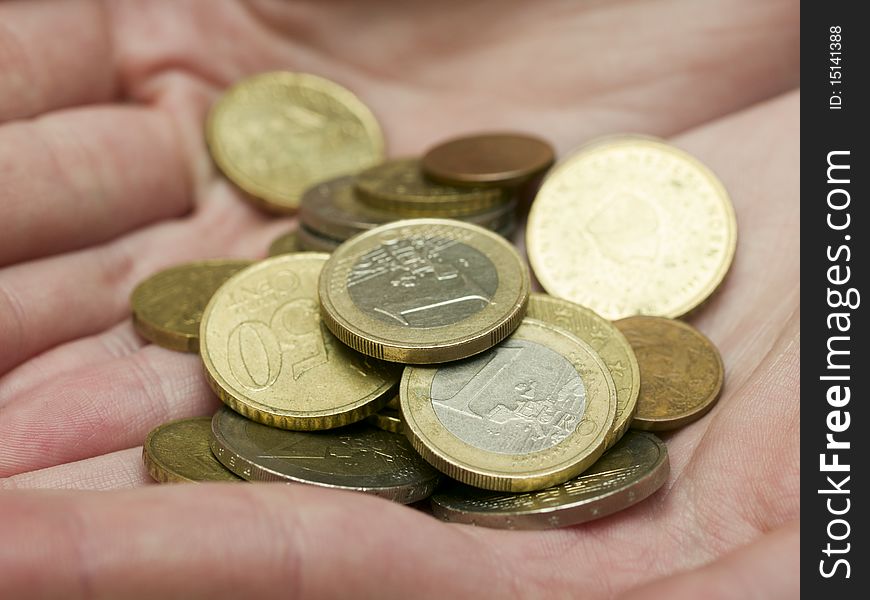 Handful of euro coins in women's hands