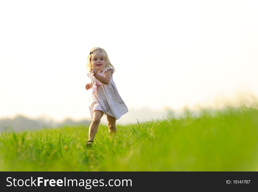 Young girl runs through a field, happy and having fun. Young girl runs through a field, happy and having fun.