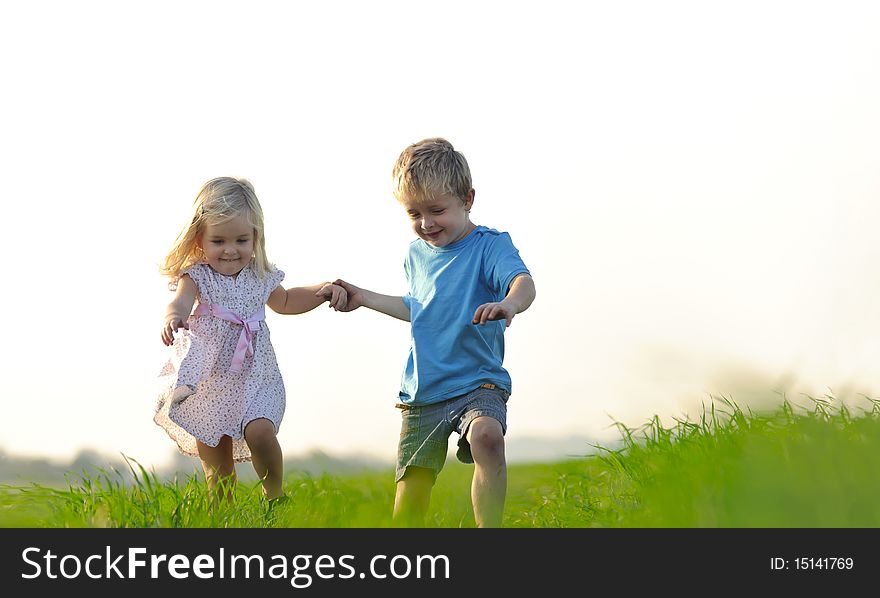 Brother and sister playing together in a field. Brother and sister playing together in a field