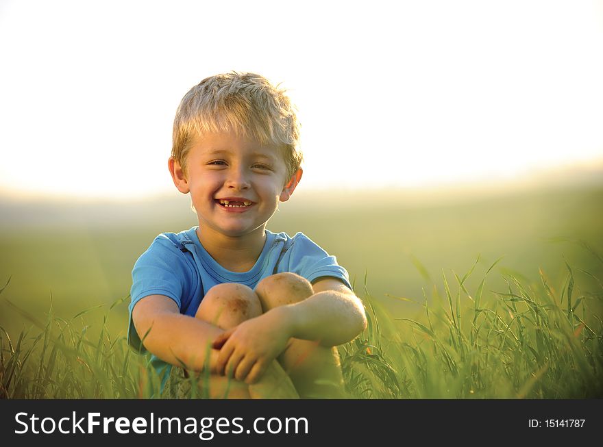 Young boy enjoys his time outside in the field. Young boy enjoys his time outside in the field