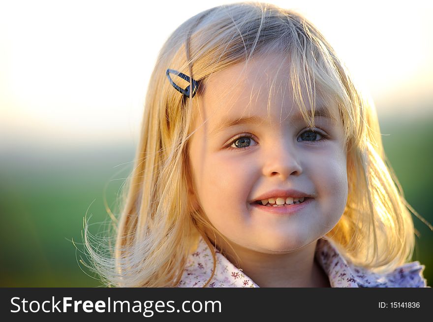 Beautiful blonde girl outside in a field with sunlight on her hair. Beautiful blonde girl outside in a field with sunlight on her hair.