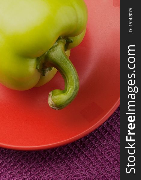 Green bell pepper on an orange saucer. Green bell pepper on an orange saucer