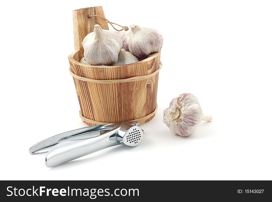 Wooden bucket with garlic heads on a white background