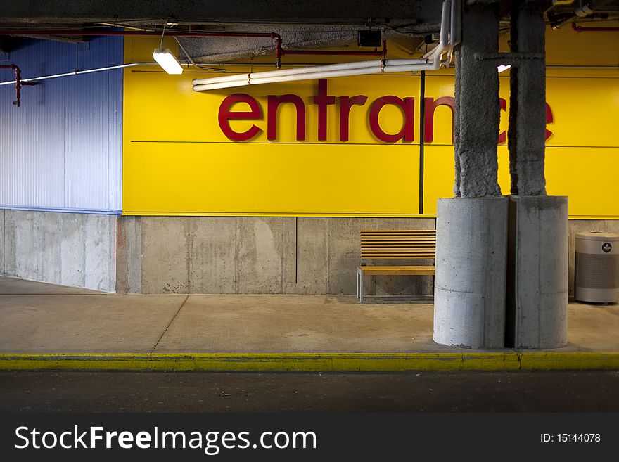 Yellow curb by the store entrance illuminated by fluorescent lights