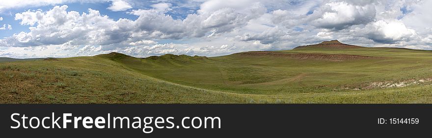 Green grass in mountains, grey cumulus clouds foretell a thunder-storm. Green grass in mountains, grey cumulus clouds foretell a thunder-storm