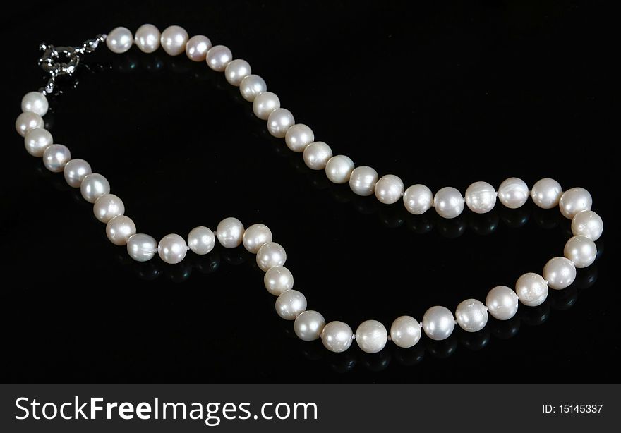 Pearl beads on a black surface