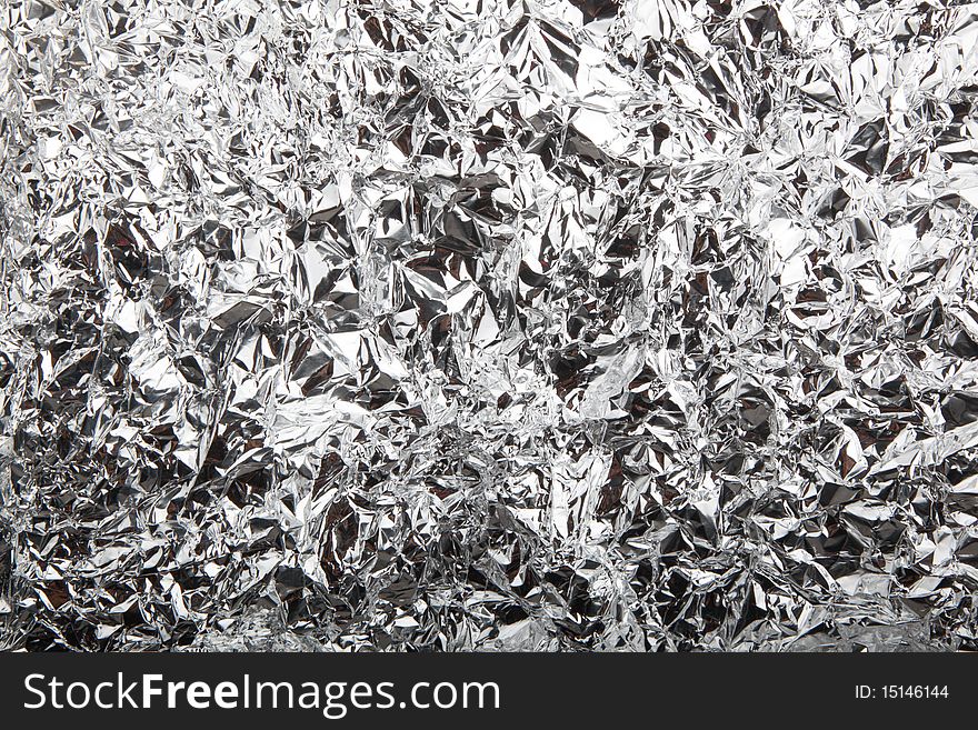 Abstract crumpled silver aluminum foil closeup background texture, in withe