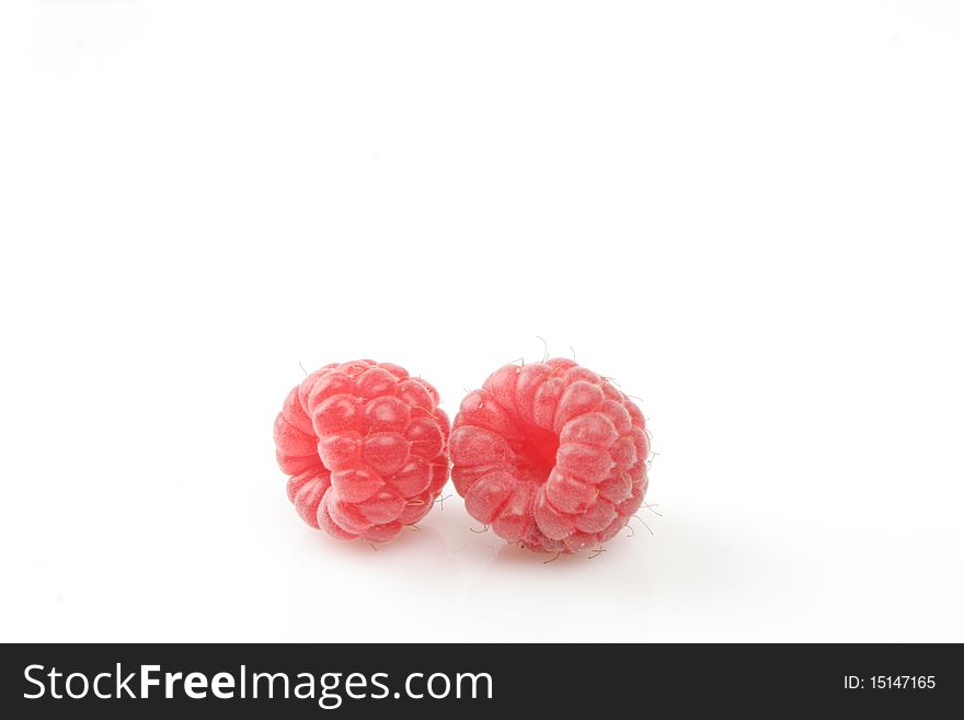 Two raspberries with soft reflection and shadow on white