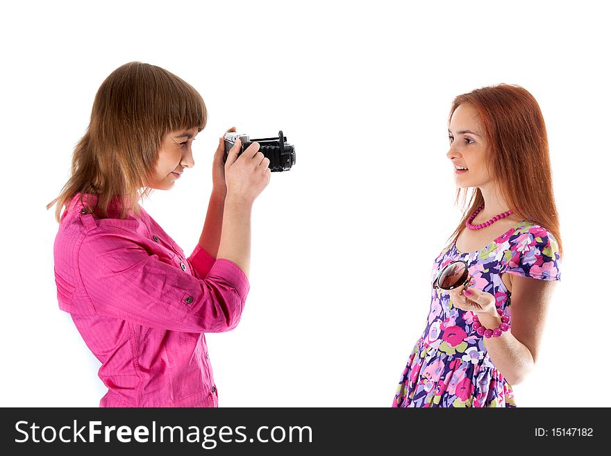 Two girls are taken pictures by old analog camera on white background