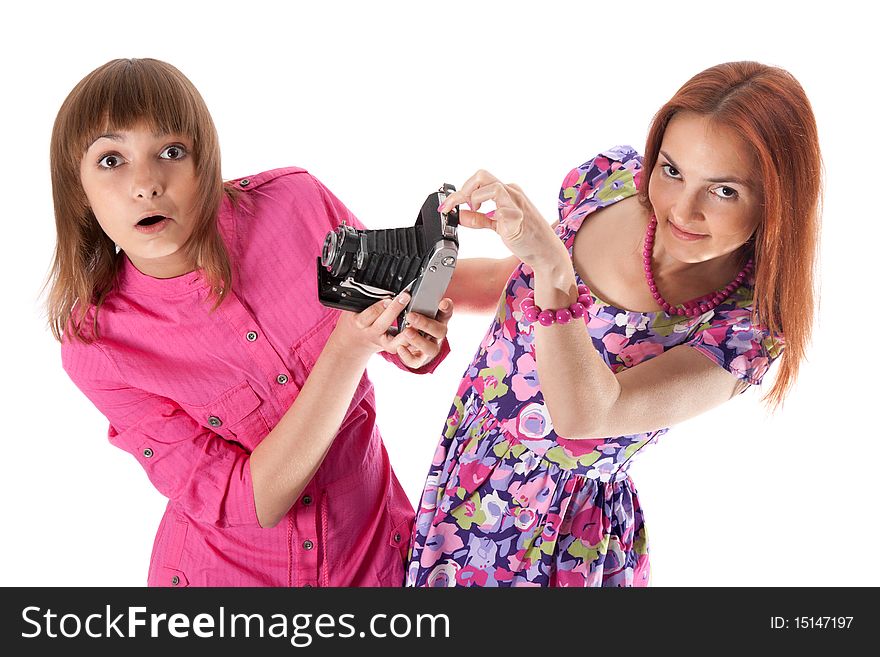 Two girls look with surprise on analog camera