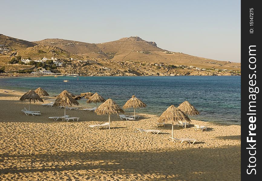 Sandy beach near the sea with umbrellas in the evening shadows...