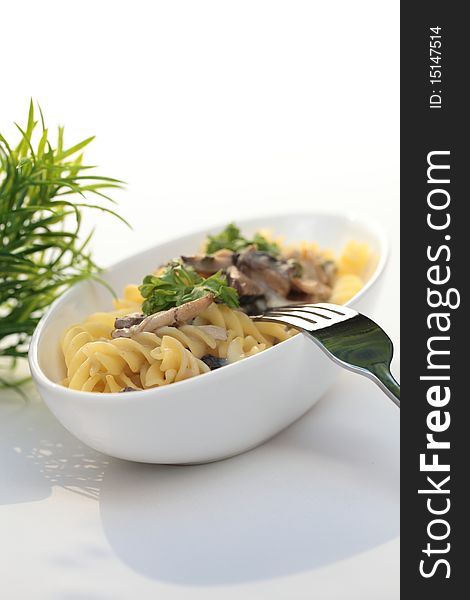 Fricassee with mushrooms in white bowl with fork