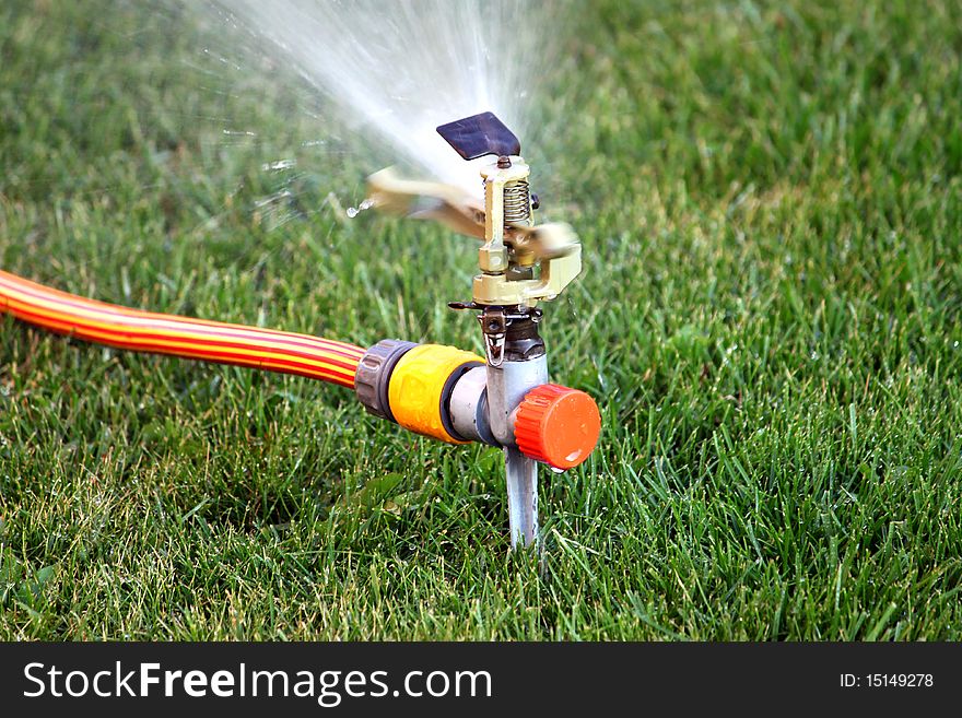 Irrigation sprinkler watering grass close-up. Irrigation sprinkler watering grass close-up