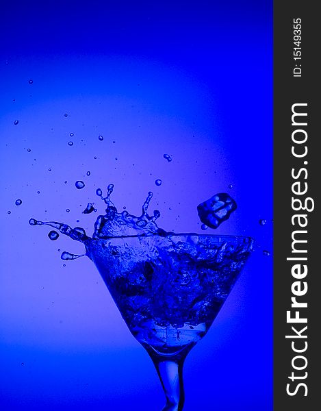 Splashing cocktail on the blue background