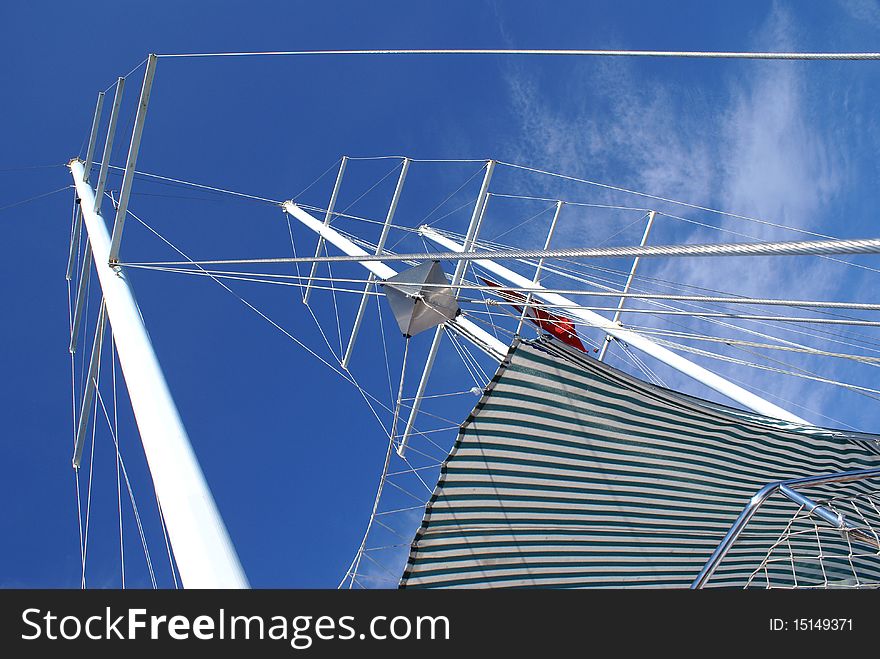 Looking up on must of sailing yacht on blue sky background. Looking up on must of sailing yacht on blue sky background