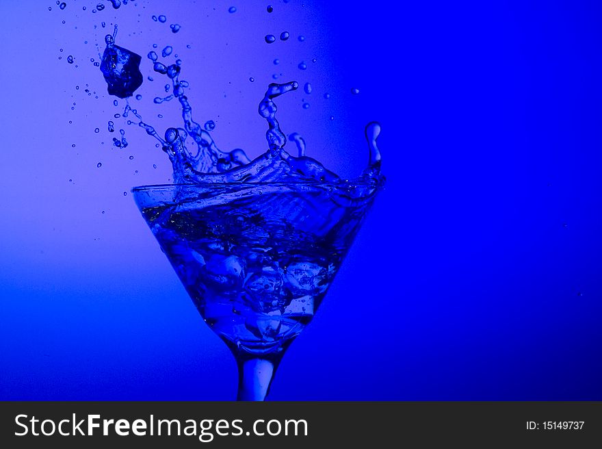 Splashing cocktail on the blue background