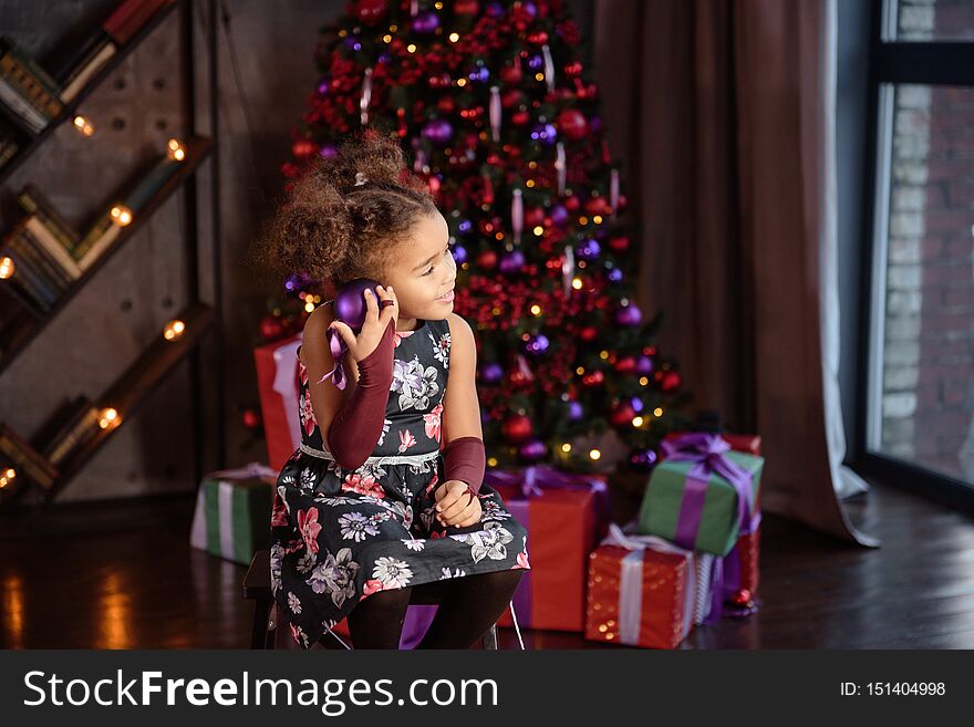 Merry Christmas! Cute Little Child Girl Is Decorating The Christmas Tree