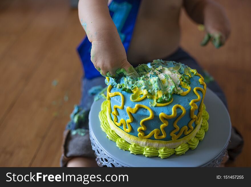 One year old boy putting his fingers into his birthday cake. One year old boy putting his fingers into his birthday cake.