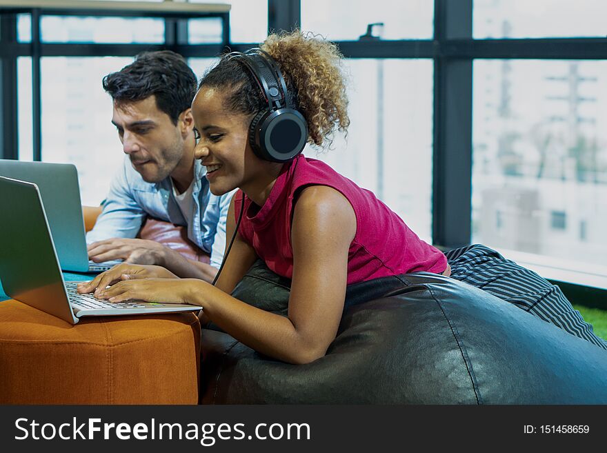 Office couple working together using laptop computer and working woman listen to music with headphone