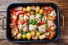 Baked Chicken Thighs, Potatoes And Vegetables In A Baking Tray On A Wooden Table Royalty Free Stock Photos