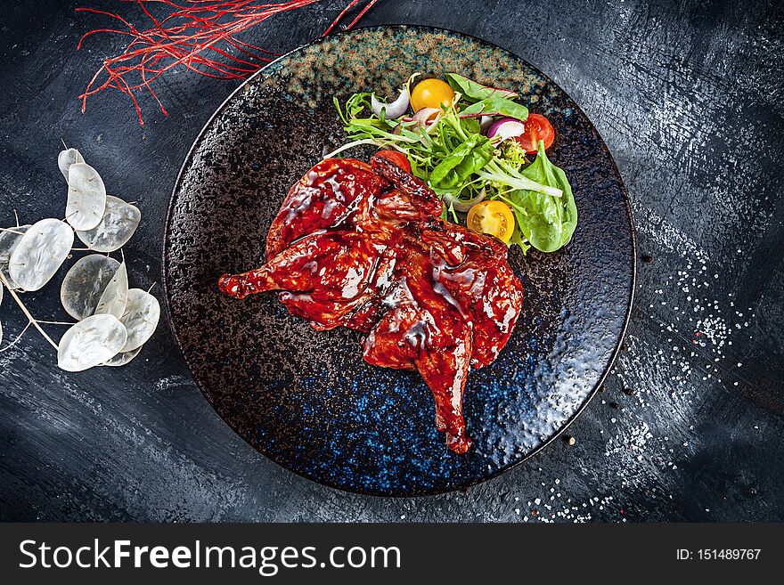 Top view on Chicken tabaka, grilled chicken. Traditional Georgian cuisine. pan-fried chicken served on dark plate. Food photo background for menu. Copy space. Flat lay