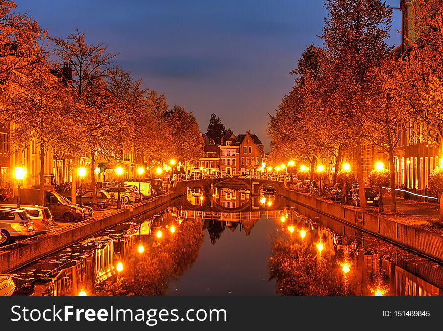 Beautiful autumn night scene in Leiden, The Netherlands still reflections in the canal water. Beautiful autumn night scene in Leiden, The Netherlands still reflections in the canal water