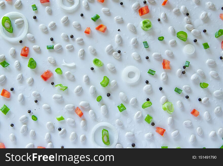 Food pattern with beans, onion, tomatoes, salt and pepper on white background