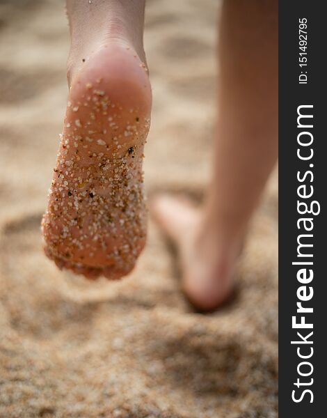 Sand on feet sole of woman walking on a beach