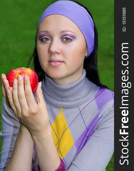 The young beautiful women holds a red apple in a hand