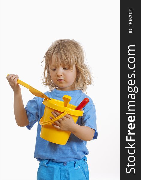 Boy with long blond hair carrying colorful plastic beach toys - isolated on white. Boy with long blond hair carrying colorful plastic beach toys - isolated on white