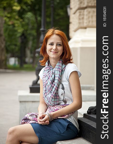 Portrait of beautiful red-haired girl. Outdoor photo.