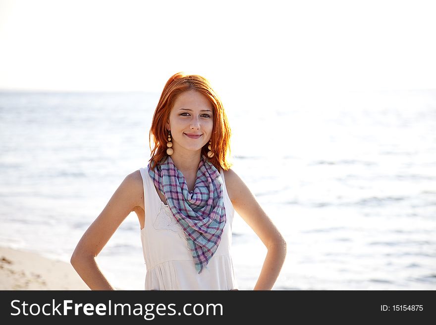 Beautiful Red-haired Girl At Sunrise On The Beach.