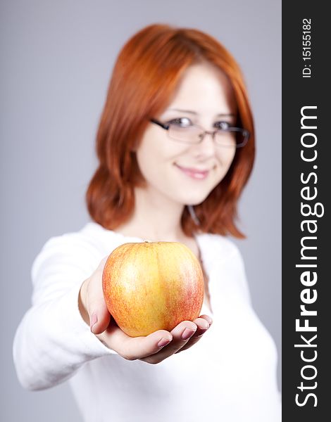 Girl with apple in hand. Studio shot.