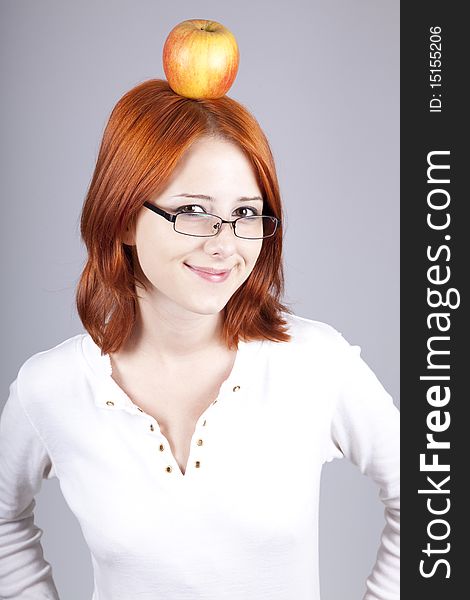 Red-haired girl keep apple on her head.