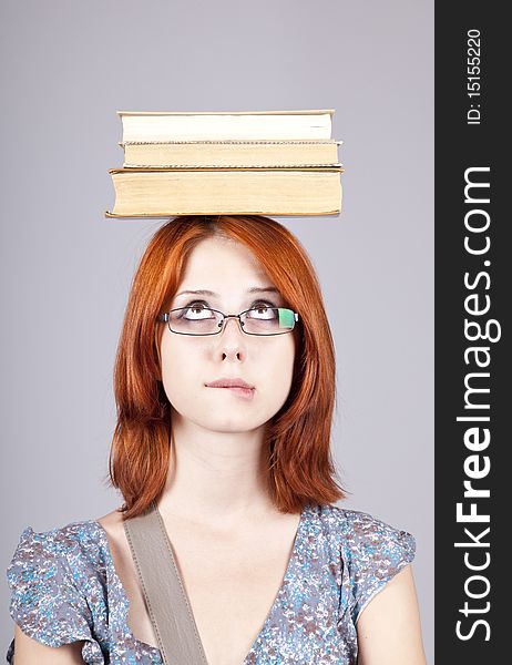 Red-haired girl keep books on her head.