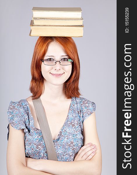 Red-haired girl keep books on her head.