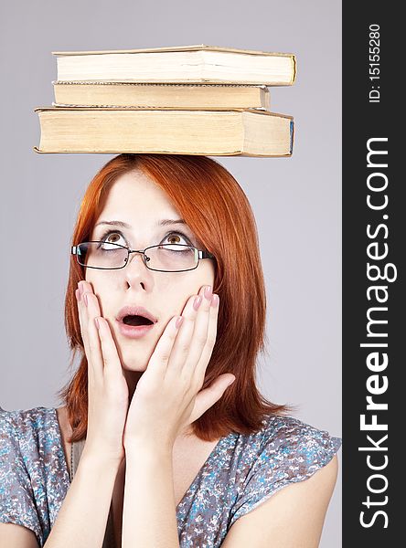 Red-haired girl keep books on her head.