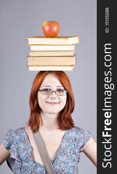 Red-haired Girl Keep Apple And Books On Her Head.