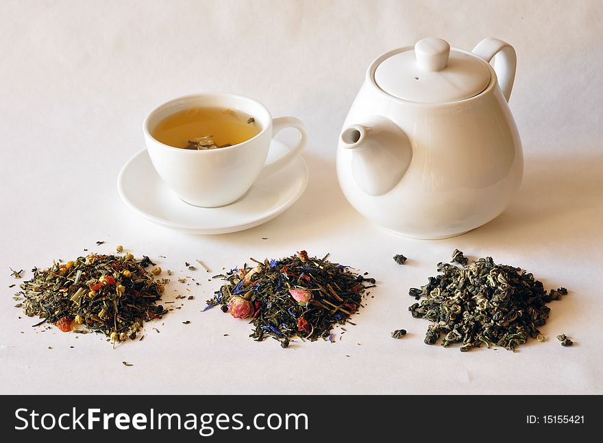 White cup with tea on a white background, alongside dry tea