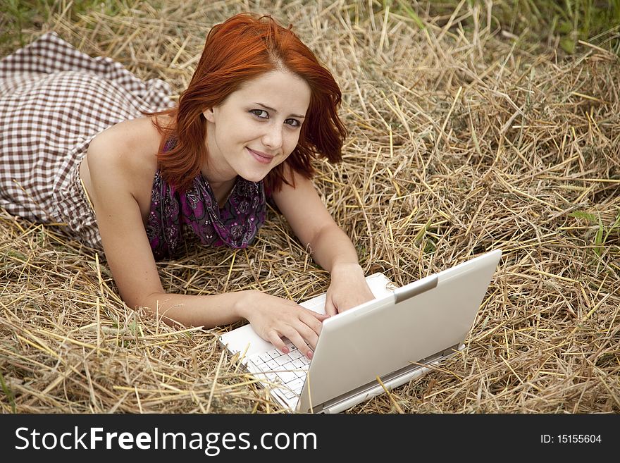 Young  fashion girl with notebook lying at field. Outdoor shot.