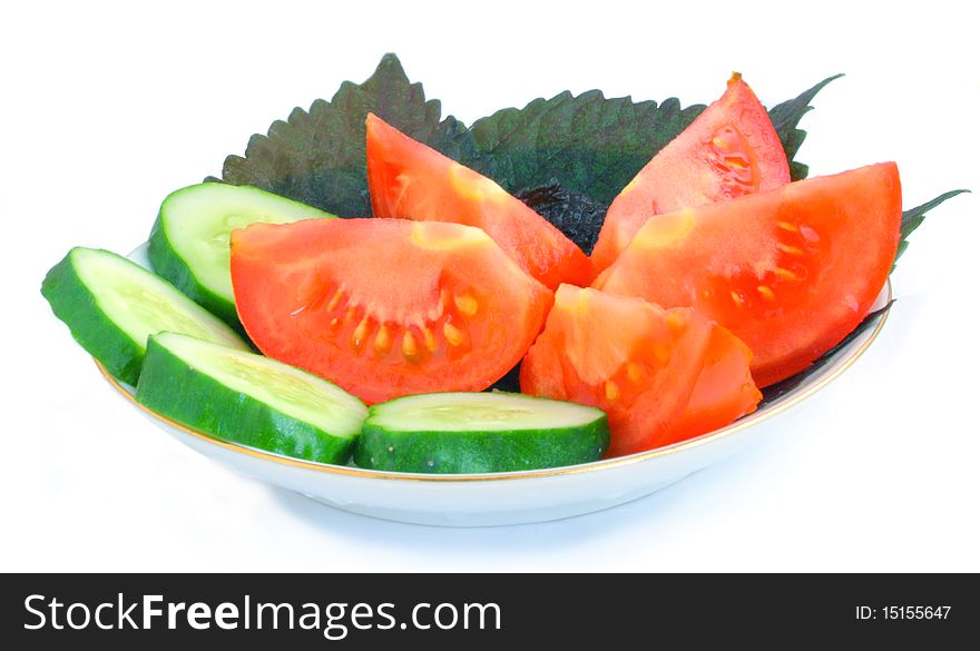 Cucumber, tomato, basil on a saucer