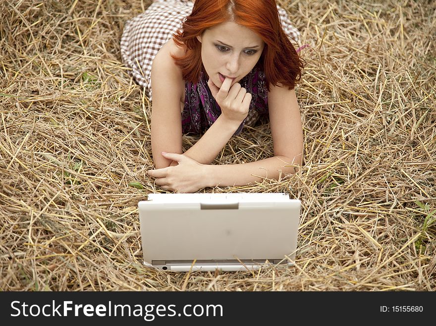 Young  fashion girl with notebook lying at field. Outdoor shot.