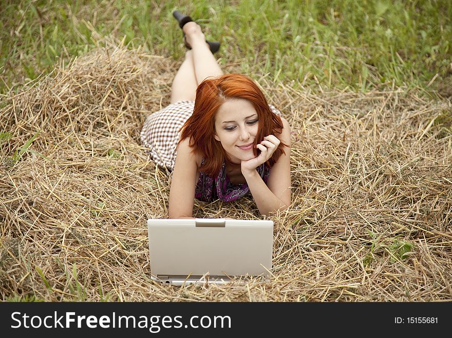 Young  fashion girl with notebook lying at field. Outdoor shot.