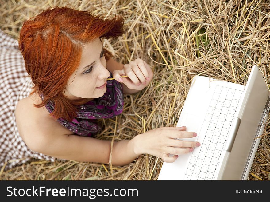 Young  fashion girl with notebook lying at field