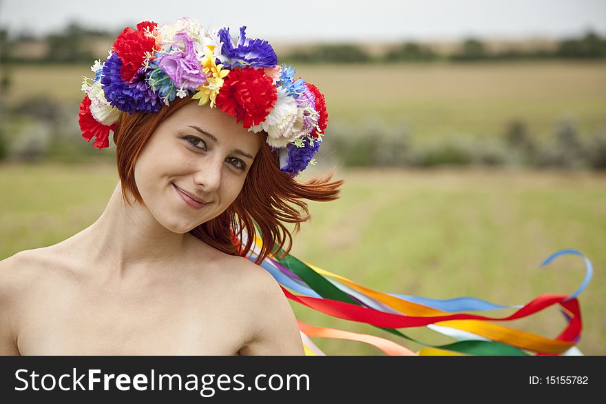 Slav girl with wreath at field. Outdoor shot.