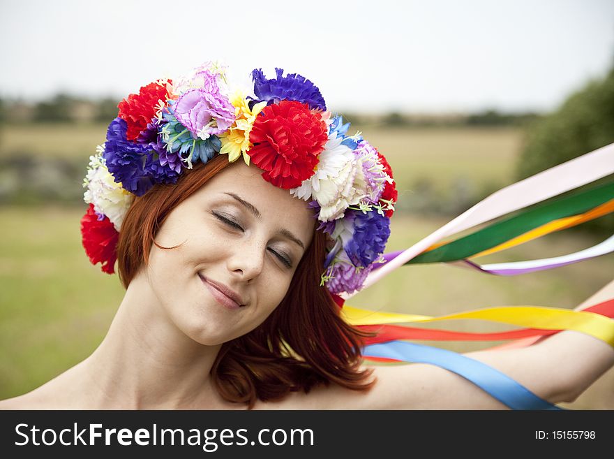 Slav girl with wreath at field. Outdoor shot.