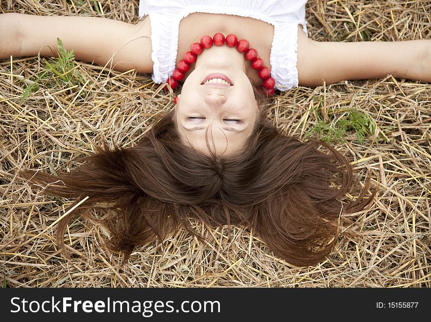 Beautiful Girl Lying At Hay Field.