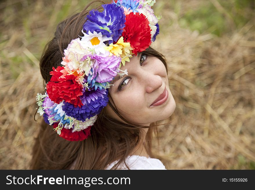 Slav girl with wreath at field